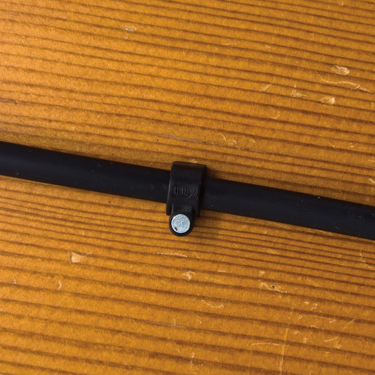 1/4" drip tubing attached to wood surface using a 1/4" drip tube clamp.