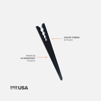A single black 6" drip tubing plastic support stake designed to hold tubing in place with features described on a white background. 