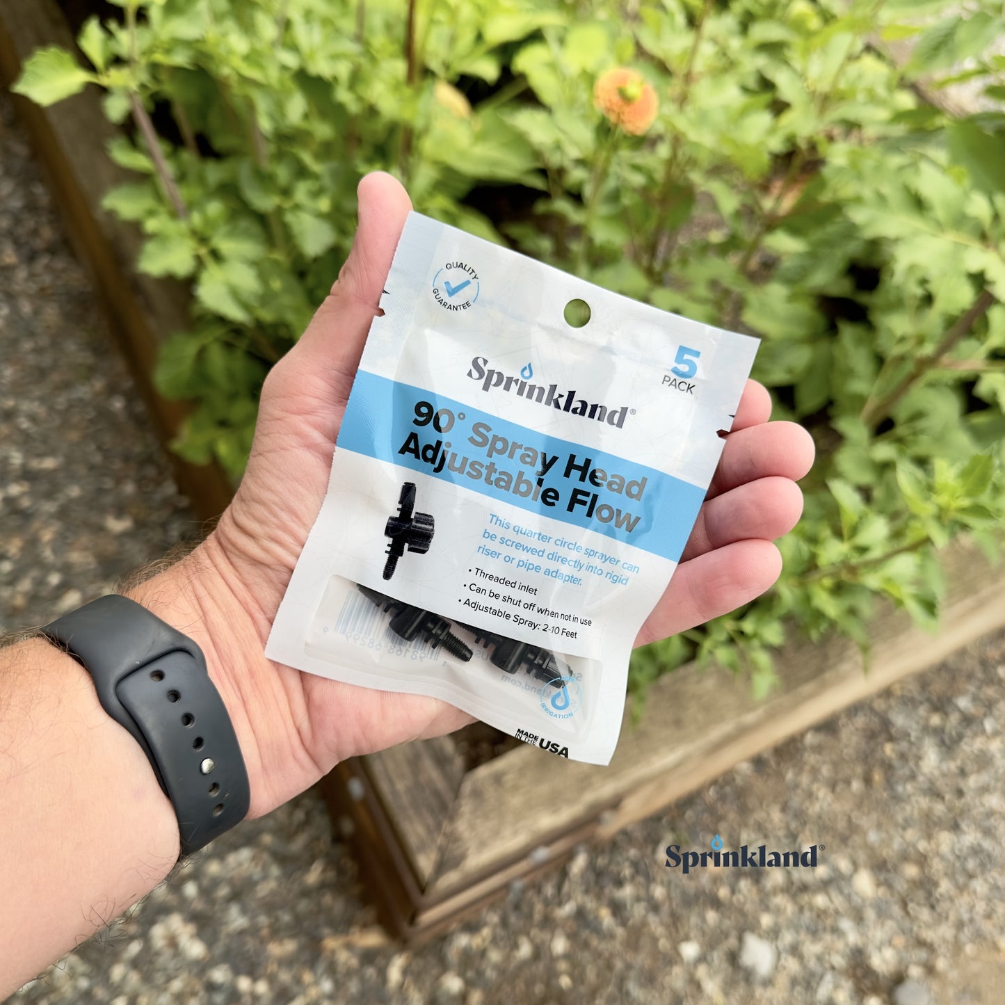 A 10 pack of  black 90-degree spray head with adjustable flow, designed for use in lawn and garden irrigation systems with plants an soil in the background. 